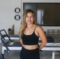 a woman standing in front of a pilates machine
