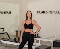 a woman posing on a pilates machine in a gym