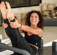 a woman is doing pilates on a pilates machine