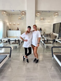 two women posing in a pilates room