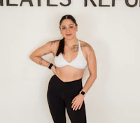 a woman posing for a photo in a black and white top and leggings